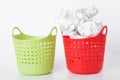 Two baskets. The green basket is empty - the red one is full. Crumpled paper in the trash can