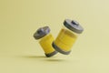 Two batteries with yellow level indicator on light yellow background Royalty Free Stock Photo