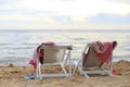 Two beach chairs on the beach.