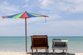 Two beach chairs and colorful umbrella on tropical beach, blue sk Royalty Free Stock Photo