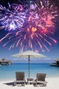 Two beach chairs in the sand by the sea and fireworks in the dark blue sky, mixed media