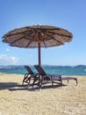 Two beach chairs with umbrella on a beach