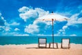 Two beach chairs and white umbrella on the tropical beach at daytime Royalty Free Stock Photo