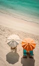 Two beach umbrella and deck chairs on stunning tropical beach sand near crystal clear ocean water. Summer vacation background.