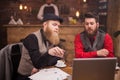 Two bearded businessmen having informal meeting in a vintage coffee shop Royalty Free Stock Photo