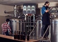 Two bearded hipster males in an apron working in a brewery factory. Royalty Free Stock Photo