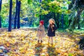 Two beautiful adorable girls walking in the fall