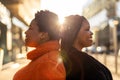 Two beautiful Afro american women standing back to back in city