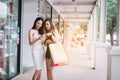 Two beautiful asian female friends standing and enjoy shopping with holding paper bag Royalty Free Stock Photo