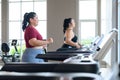 Two beautiful, Asian overweight women working out on treadmill in fitness club together. Weight loss workout, healthy lifestyle Royalty Free Stock Photo