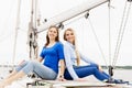 Two beautiful, attractive young girls a hiving a rest on yacht.