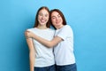 Two beautiful best friends hugging while standing in the studio Royalty Free Stock Photo