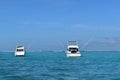 Two beautiful boats with booms deployed to deport fishing lines.