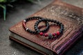 Two beautiful bracelets made of natural stones, on a notebook made of red leather alligator. Crocodile texture