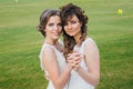 Two beautiful brides dancing on the green field Royalty Free Stock Photo