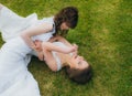 Two beautiful brides lying on the green field