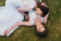 Two beautiful brides lying on the green field