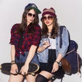 Two beautiful brunette women (girls) teenagers spend time together having fun, make funny faces. Casual hipster outfit, jeans Royalty Free Stock Photo