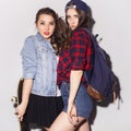 Two beautiful brunette women (girls) teenagers spend time together having fun, make funny faces. Casual hipster outfit, jeans Royalty Free Stock Photo