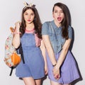 Two beautiful brunette women (girls) teenagers spend time together having fun, make funny faces. Jeans dresses outfit Royalty Free Stock Photo