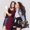 Two beautiful brunette women (girls) teenagers spend time together having fun, make funny faces, making selfie. Casual hipster Royalty Free Stock Photo