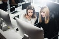 Two beautiful business woman working at modern lightfil office.Handsome girls at working process on desk top computer Royalty Free Stock Photo