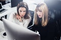 Two beautiful business woman working at modern lightfil office.Handsome girls at working process on desk top computer Royalty Free Stock Photo