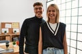 Two beautiful business workers wearing business style standing at the office looking positive and happy standing and smiling with