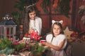 Two beautiful children, sisters, having Christmas party at family wooden cottage, cozy Christmas atmosphere.