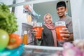 beautiful couple muslim breaking the fast iftar in front of the open fridge Royalty Free Stock Photo