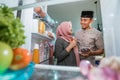 beautiful couple muslim breaking the fast iftar in front of the open fridge Royalty Free Stock Photo