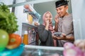 beautiful couple muslim breaking the fast iftar in front of the open fridge Royalty Free Stock Photo