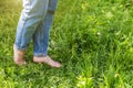 Two beautiful female feet walking on grass in sunny summer morning. Light step barefoot girl legs on soft spring lawn in garden or Royalty Free Stock Photo