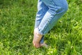 Two beautiful female feet walking on grass in sunny summer morning. Light step barefoot girl legs on soft spring lawn in garden or Royalty Free Stock Photo