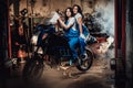 Two female mechanic sitting on sportbike in authentic workshop garage