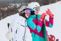 Two beautiful female snowboarders taking a selfie