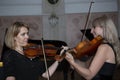 Two beautiful female violinists playing violin