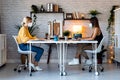 Two beautiful freelance business women seller wearing a hygienic face mask while working with computer in their startup small Royalty Free Stock Photo