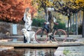 Two beautiful friends talking while walking with their dog and bike on a bridge in autumn Royalty Free Stock Photo