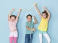 Two beautiful and funny girls and one cool boy playing with a lot of slime in front of blue background and having a lot of fun Royalty Free Stock Photo