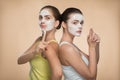 Two beautiful girls applying facial cream mask and Royalty Free Stock Photo