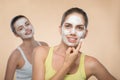 Two beautiful girls applying facial cream mask and Royalty Free Stock Photo