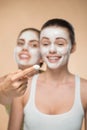 Two beautiful girls applying facial cream mask and Royalty Free Stock Photo