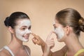 Two beautiful girls applying facial cream mask and Royalty Free Stock Photo