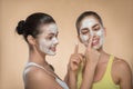 Two beautiful girls applying facial cream mask and Royalty Free Stock Photo