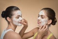 Two beautiful girls applying facial cream mask and Royalty Free Stock Photo