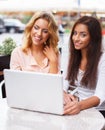 Two beautiful girls in cafe with laptop Royalty Free Stock Photo