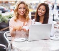 Two beautiful girls cups and laptop Royalty Free Stock Photo