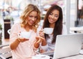 Two beautiful girls cups and laptop Royalty Free Stock Photo