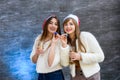 Two beautiful girls in fur jackets and champagne celebrating New Year Royalty Free Stock Photo